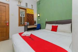 诗都阿佐OYO 91292 Pondok Inap Shofwa 1的一间卧室配有一张床铺,床上铺有红色毯子