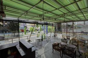 诗都阿佐OYO 91292 Pondok Inap Shofwa 1的一间带桌椅和绿色天花板的餐厅