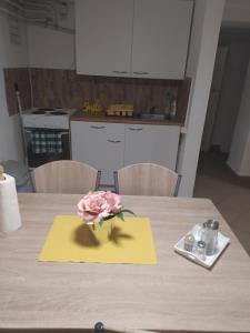 佩奇Kolpingház Pécs的一张桌子上黄色餐巾上的粉红色玫瑰