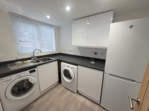 科尔切斯特Midland Close Bungalow - With separate office space by Catchpole Stays的白色的厨房配有洗衣机和烘干机