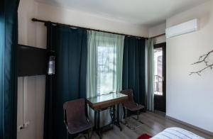波尔塔里亚Stagiates Guest House at Pelion的客房设有桌椅和窗户。