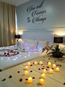 瓜拉丁加奴TY Hotel的卧室配有蜡烛和玫瑰,位于床上