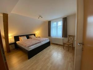 GaißauBodensee Wohnung 3 mit Privatstrand的卧室配有床、椅子和窗户。