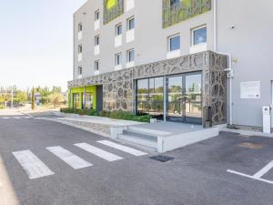 克罗的圣马丁B&B HOTEL Saint-Martin-de-Crau Alpilles Camargue的大楼前的一个空停车位