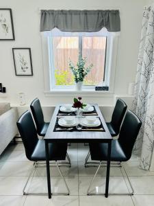 温哥华2BR 1.5BA Full Kitchen Private Guest House - Free Parking - Central Location的一张带黑色椅子的餐桌和窗户