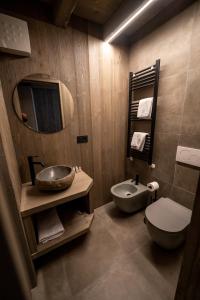 蓬泰迪莱尼奥Le Suites de San Campel RTA的一间带水槽、卫生间和镜子的浴室