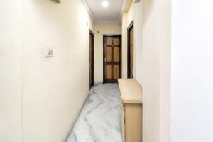那格浦尔SPOT ON Hotel Sanskriti的走廊设有白色的墙壁和木桌