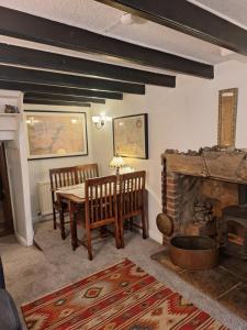 斯泰兹The Cottage, High Street Staithes的一间带桌子和壁炉的用餐室