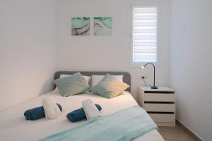 科斯塔特吉塞Lanzahost Carmenes Comfort的一间卧室配有一张带蓝色和白色枕头的床