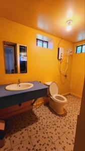 瓜隆岛Sweet Jungle Bungalows的一间带水槽和卫生间的浴室以及一部电话