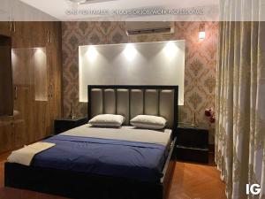 拉合尔3 Bedroom Furnished Holiday Home Near Valencia Town, Lake City & Ring Road的一间卧室配有一张大床,提供蓝色的床单和枕头