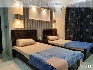 拉合尔3 Bedroom Furnished Holiday Home Near Valencia Town, Lake City & Ring Road的配有两张床的旅馆客房