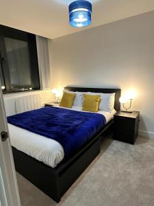 曼彻斯特1 Bed Apartment near Old Trafford with free car park的一间卧室配有一张带蓝色床单和黄色枕头的床。