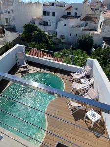 马翁Casa S’Arraval的阳台的带椅子的甲板和游泳池