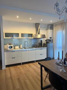 马格拉Ca’ Uccelli-Stupendo Appartamento 5 min da Venezia的厨房配有白色橱柜、桌子和用餐室。