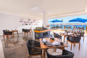 沙姆沙伊赫Naama Bay Suites & SPA的一间带桌椅的海景餐厅