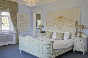 斯托克绿林SPA酒店的卧室配有白色的床和吊灯。