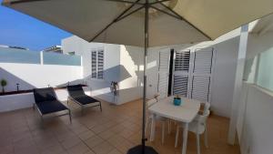 宏达海滩Casa Ila Flower Beach的庭院配有遮阳伞和桌椅。