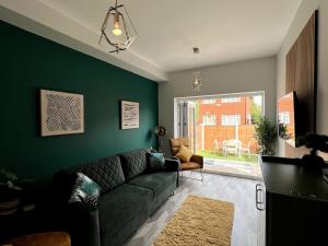 HenwickModern 2 Bed House With EV Parking的带沙发和绿色墙壁的客厅