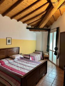 曼托瓦诺港Agriturismo La Rasdora的卧室设有2张床和木制天花板。
