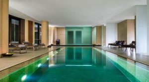 米兰米兰宝格丽酒店的酒店大堂的游泳池,配有椅子