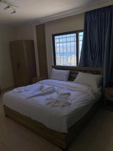 亚喀巴Mariam Boutique Hotel的一间卧室配有一张带白色床单的床和一扇窗户。