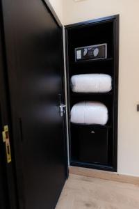 卡萨布兰卡Ennesma Hotel的浴室设有黑色的门,配有一叠毛巾