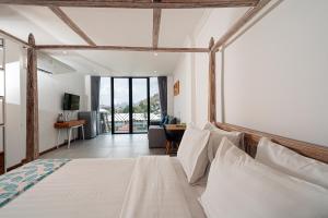 纳闽巴霍Komodo Suites Downtown Managed by CPM Bali的一间卧室设有一张床和一间客厅。