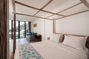 纳闽巴霍Komodo Suites Downtown Managed by CPM Bali的一间卧室设有一张床和一个大窗户