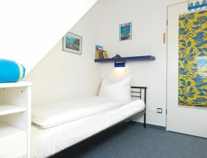 高尔维茨Landhaus am Meer Kleine Krabbe的小房间设有白色的床和架子