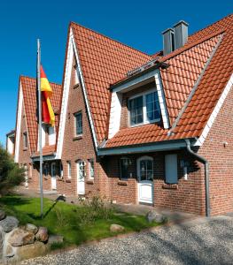 高尔维茨Landhaus am Meer Kleine Krabbe的红屋顶和旗帜的房子