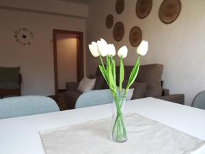 格拉纳达H&H Suite Plaza de Toros的坐在桌子上的白花花瓶