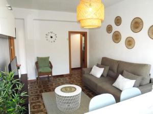 格拉纳达H&H Suite Plaza de Toros的客厅配有沙发和桌子