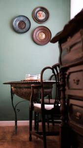 耶路撒冷Tzefania Hotel的墙上一张桌子,上面有椅子和盘子