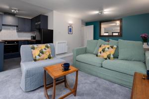 南安普敦2 Bedroom City Centre Apartment, Sleeps up to 6 Guests, Free Parking的客厅配有两张绿色沙发和一张桌子