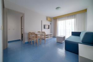 坎布里尔斯奥利马尔二号公寓的客厅配有蓝色的沙发和桌子
