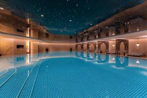成都成都瑯珀·凯悦臻选酒店的大楼内一个蓝色的大型游泳池