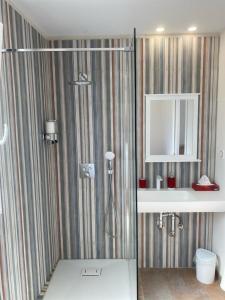马翁Casa S’Arraval的带淋浴、盥洗盆和镜子的浴室