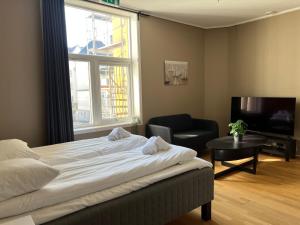 卑尔根Vestre Torggaten 20的卧室配有床、椅子和窗户。