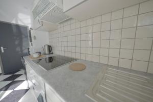 沙勒罗瓦Studio Didine的白色瓷砖厨房配有台面