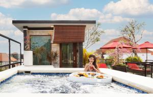 坎古Winy Estate - Luxury Villa with Rooftop Jacuzzi的坐在游泳池浴缸中的女人