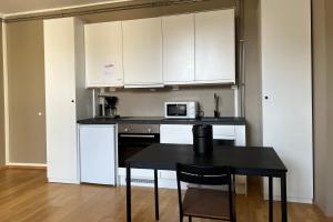 卑尔根Vestre Torggaten 20的厨房配有白色橱柜和带微波炉的桌子。