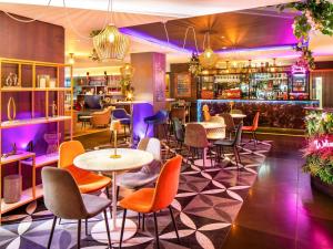 伦敦伦敦桥美居酒店的一间设有五颜六色桌椅的餐厅和一间酒吧
