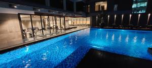 马尼拉Bayprime Hotel的一座拥有蓝色灯光的大型游泳池