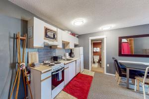 大白山Whitefoot Lodge 342/344的厨房配有白色家电和红色地毯的桌子