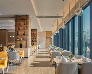 成都成都生物城凯悦嘉轩酒店的餐厅设有桌椅和大窗户。
