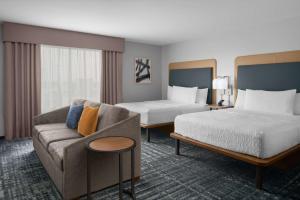 夏洛特Homewood Suites By Hilton Charlotte Uptown First Ward的酒店客房,设有两张床和一张沙发