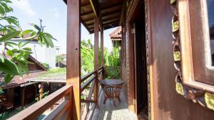 金巴兰RedDoorz at Villa Krisna Balangan Beach的房屋的阳台,上面有长凳