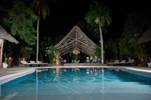马林迪Saffron Garden Malindi的夜间在度假村前的游泳池