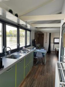 莱茵河畔阿尔芬Aangenaam op de Rijn, woonboot, inclusief privé sauna的一个带水槽的厨房和一张书桌